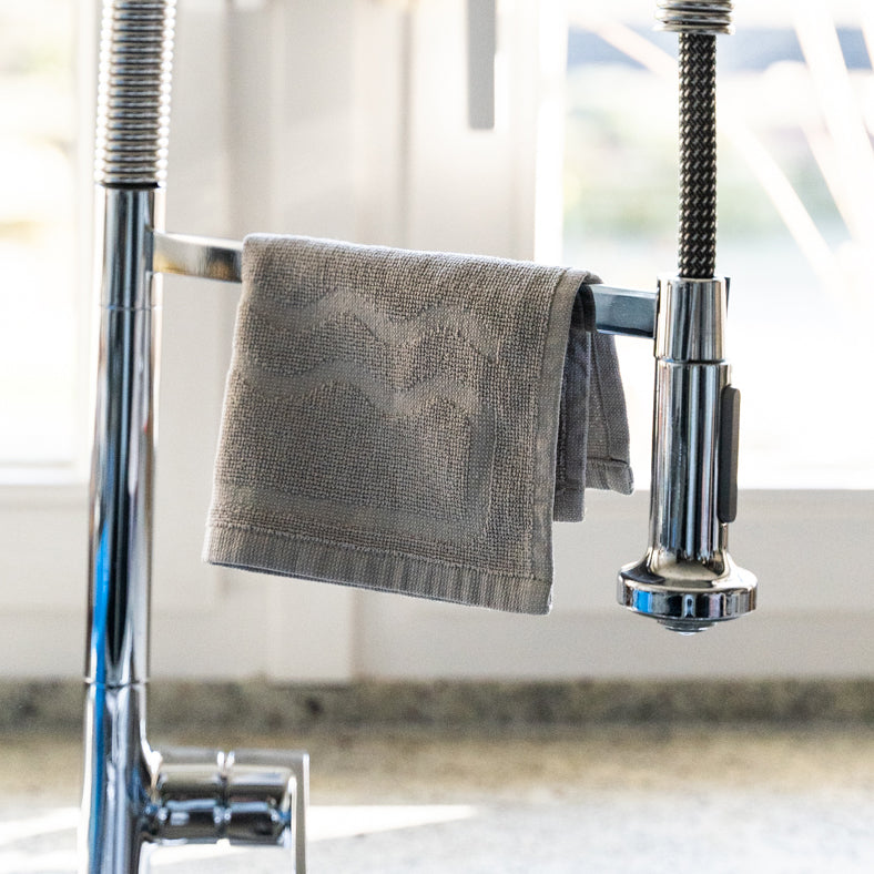 Ein Güppyfriend Spültuch über einen Wasserhahn gehängt.